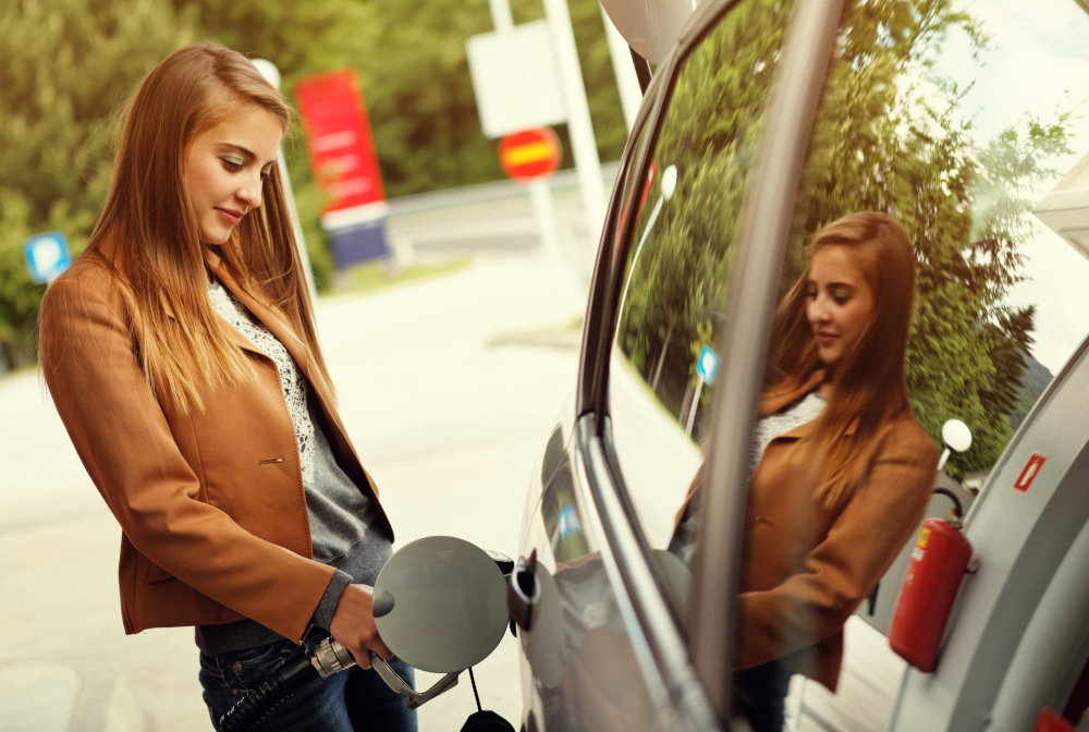 Young Woman Refilling Car With Gas Pump